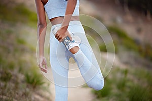 Fitness, woman and leg for stretching in nature before training, jog or exercise outdoors. Runner, athlete girl and warm