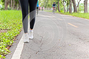 Fitness woman legs exercise walking on park trail in the morning.