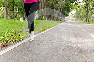 Fitness woman legs exercise walking on park trail in the morning.