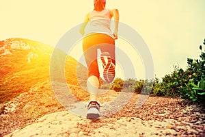 Fitness woman legs running on trail