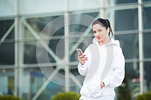 Fitness. Woman listening music on phone while exercising Outdoors - Sport and healthy lifestyle concept