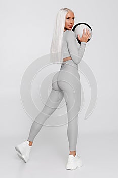 Fitness woman with med ball. Athletic girl on gray background