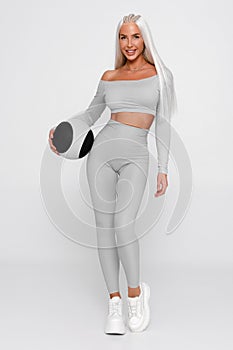 Fitness woman with med ball. Athletic girl on gray background