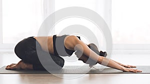 Fitness, woman meditating in child`s pose at home