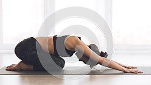 Fitness, woman meditating in child`s pose at home photo