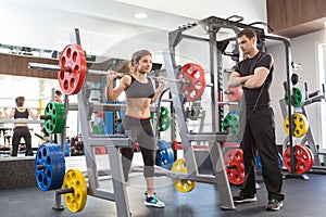 Fitness woman and personal trainer in gym