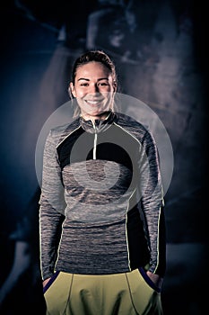 Fitness woman portrait at the gym. Smiling happy female fitness instructor looking at camera.