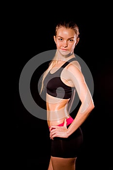 Fitness woman portrait isolated on black background. Smiling hap