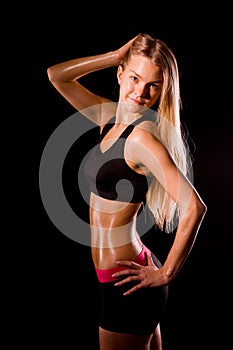 Fitness woman portrait isolated on black background. Smiling hap