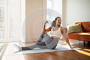 fitness woman practicing yoga doing seated spinal twists indoor