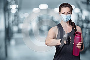 Fitness woman protective mask showing hand good