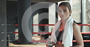 Fitness woman resting taking a break with water bottle drink outside after training