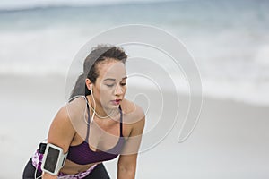 Fitness Woman resting after work out on the beach at cloudy winter day