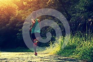 Fitness woman runner athlete running on forest trail.