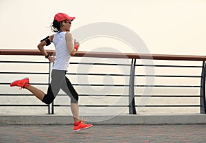 Fitness woman runner athlete running at seaside road