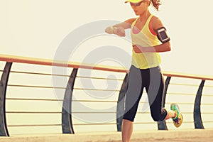 Idoneidad una mujer corredor control su correr elegante mirar sobre el costa 