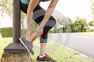 Fitness woman runner feel pain on ankle leg. Outdoor exercise activities concept