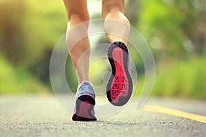 Fitness woman runner legs running on forest trail