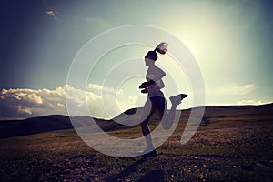 fitness woman runner running on grassland trail