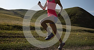 Fitness woman runner running on grassland trail