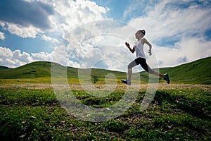 fitness woman runner running grassland trail