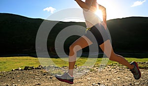 Fitness woman runner running on mountain trail