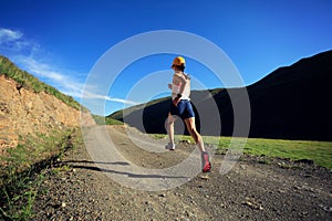 Fitness woman runner running on mountain trail