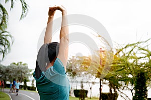 Fitness woman runner stretching arm before run. Outdoor exercise activities concept
