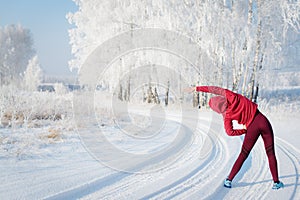 Fitness woman runner on sunny winter road