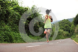 Fitness woman running at forest trail