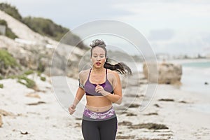Fitness Woman Running by the Ocean at cloudy winter day
