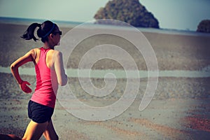 Fitness woman running at sunrise beach