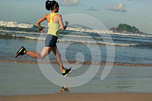 Fitness woman running on sunrise beach