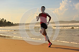 Fitness woman running on sunrise beach