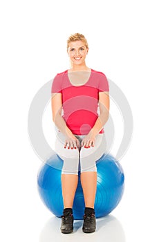 Fitness woman sitting on pilates ball