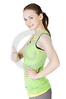 Fitness woman in sport clothes gesturing thumbs up