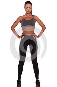 Fitness woman in sport style standing against isolated white background