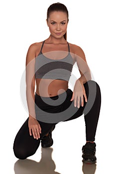 Fitness woman in sport style standing against isolated white background