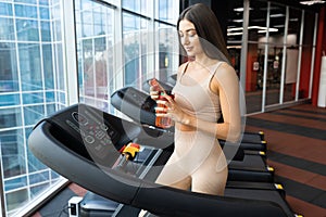 Fitness woman with sports bottle in her hands in the gym.