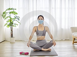 Fitness woman streching Relaxing after training and wearing  protectve face mask during Covid 19