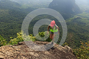 fitness woman trail runner running at mountain top