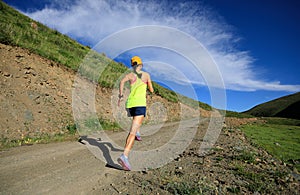 Fitness woman trail runner running on mountain trail