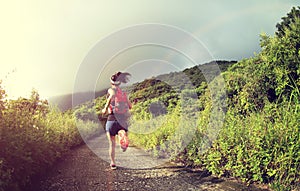 Fitness woman trail runner running on seaside mountain