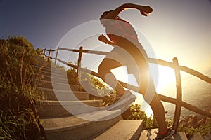 Fitness woman trail runner running on seaside mountain stairs