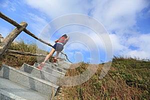 Fitness woman trail runner running up on mountain stairs