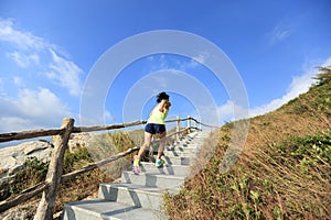 Fitness woman trail runner running up on mountain stairs