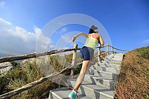 Fitness woman trail runner running up on mountain stairs