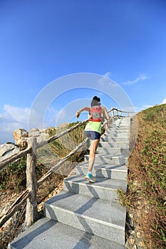 fitness woman trail runner running up on mountain stairs