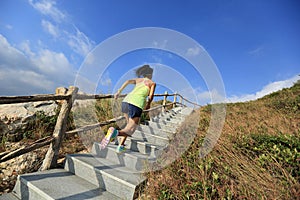 Fitness woman trail runner running up on mountain stairs