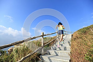 Fitness woman trail runner running up on mountain stairs